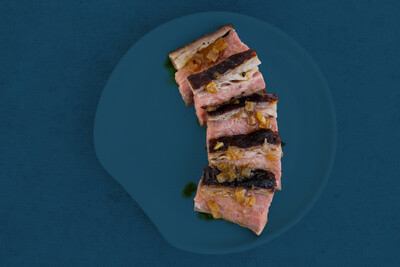 image of sliced orange blossom tri tip steak on blue background